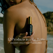 A woman with long dark hair in a bikini holds a black and gold bottle of THE GOLDEN SECRETS Hydrate & Heal Duo against her back on a beach. Text reads: 12 Products in One Bottle. Ancient | Multi-Use | Treasured. Unlock the secret to supporting your skin barrier and nourishing your microbiome with every luxurious drop.