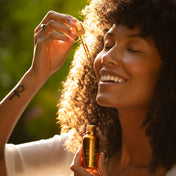 woman with youth beauty face oil dropper on cheek