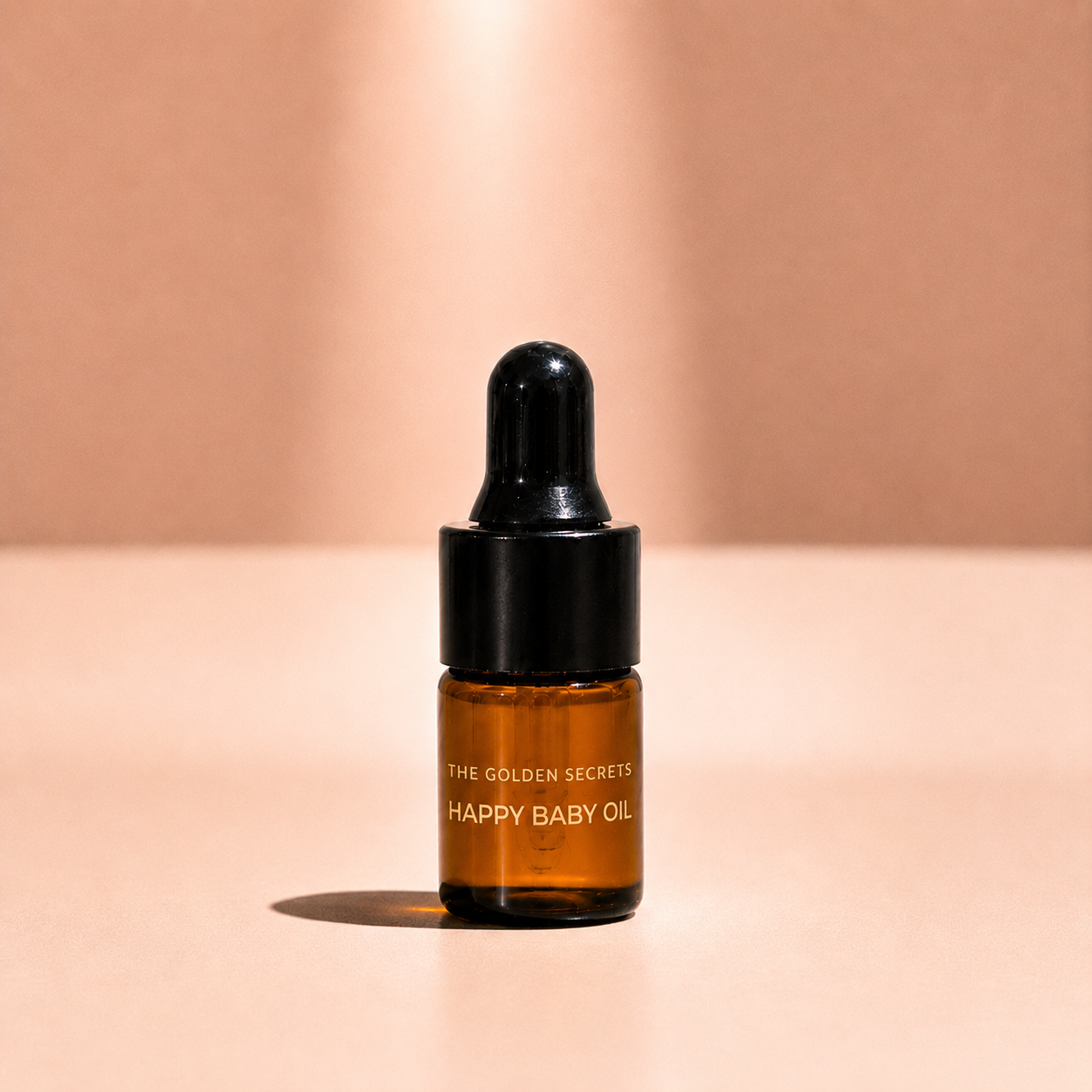 A small amber dropper bottle from Deluxe Minis stands on a beige surface against a softly lit beige background.