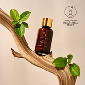A brown bottle labeled Magic Brightening Powder 3-in-1 by THE GOLDEN SECRETS rests on a twisted wooden branch with green leaves, next to a stamp reading Third-Party Heavy-Metal Tested. Infused with pearl powder, this 3-in-1 brightening powder delivers natural radiance and gentle exfoliation for glowing skin.
