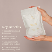 A hand holds a white bag labeled THE GOLDEN SECRETS Royal Codes Bath Soak. Text highlights benefits: this mineral-rich soak from THE GOLDEN SECRETS helps ease tension, calm nerves, leaves skin radiant, and transforms your bath into a soothing ritual. The pale background combines cream and gold tones.