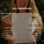 A woman smiles while holding a bag labeled "Royal Codes Bath Soak" by THE GOLDEN SECRETS. Text highlights key ingredients—Diatomaceous Earth, Ylang-Ylang, Zechstein Magnesium Chloride, and Rose Damascena—along with their skincare benefits. Experience the rejuvenating effects of this mineral-rich bath soak as it soothes and nourishes your skin.