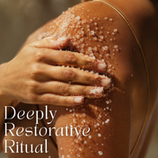 A close-up of a hand applying Royal Codes Bath Soak by THE GOLDEN SECRETS to a shoulder, highlighting smooth skin. The text reads Deeply Restorative Ritual in white.