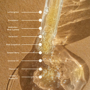 A dropper containing oil rests on a brown surface, its label listing ingredients like lemongrass, eucalyptus, Australian blue cypress, geranium, pink grapefruit, juniper berry, coconut oil, vitamin E, and golden jojoba oil—the ideal Body Oil from THE GOLDEN SECRETS to use with your favorite Gua Sha Body Tool or to include in the Body Sculpting Kit.