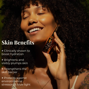 A smiling woman with curly hair holds the Clear Confident Skin Kit by THE GOLDEN SECRETS to her face. Text beside her highlights key benefits: hydration, brightening, barrier strengthening, and protection from stressors and blue light—for clearer and more radiant-looking skin every day.