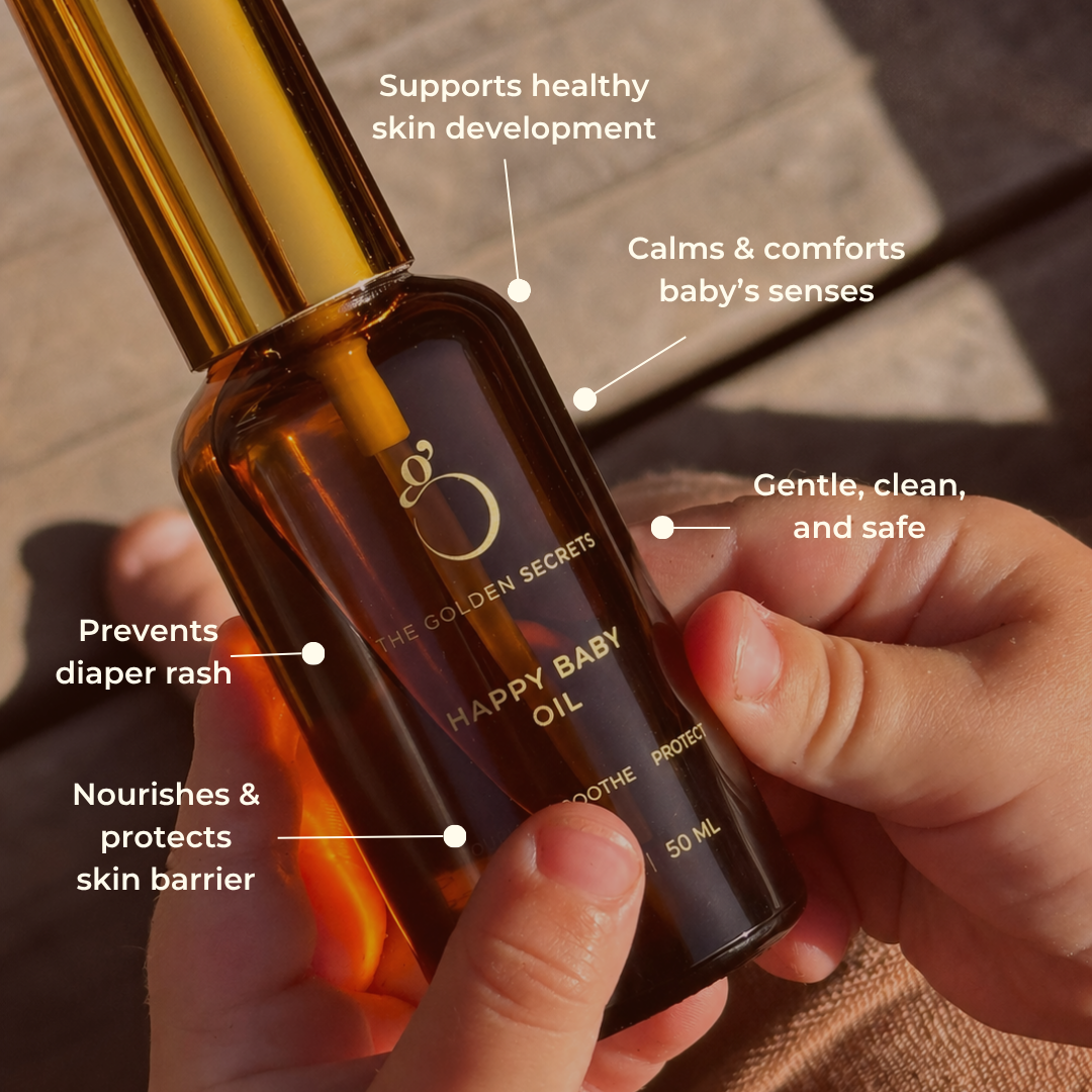 Hand holding a bottle of 'The Golden Secrets Happy Baby Oil' with text highlighting its benefits.