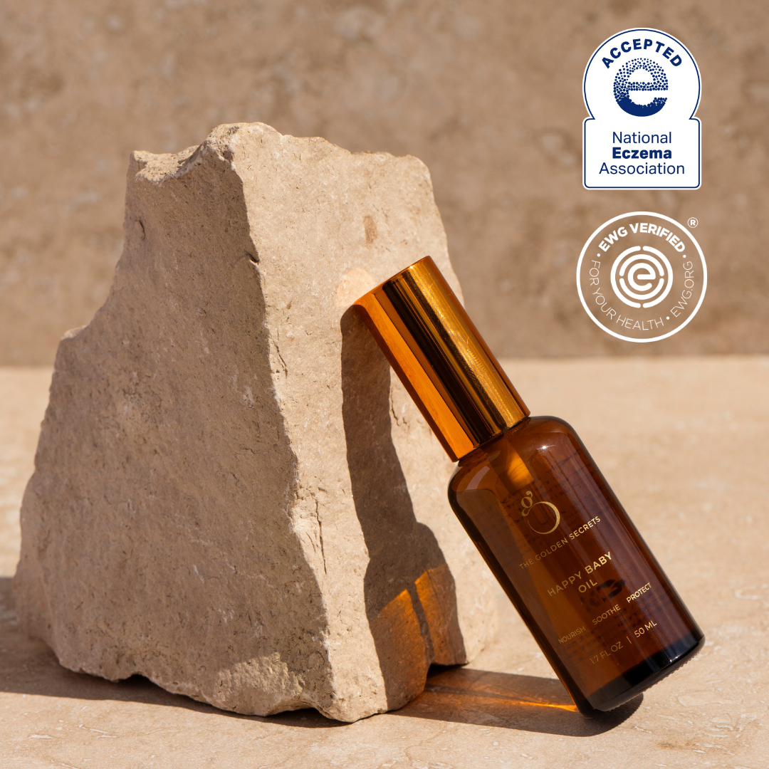 Brown bottle with gold cap on a stone surface, with National Eczema Association acceptance badge.