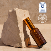 Brown bottle with gold cap on a stone surface, with National Eczema Association acceptance badge.