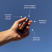 Hand holding a skincare bottle with text on a blue background