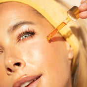 woman with youth beauty face oil dropper on cheek